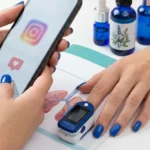 Dłonie z niebieskimi paznokciami: jedna trzyma telefon z Instagramem, druga z pulsoksymetrem na tle rysunku płuc.